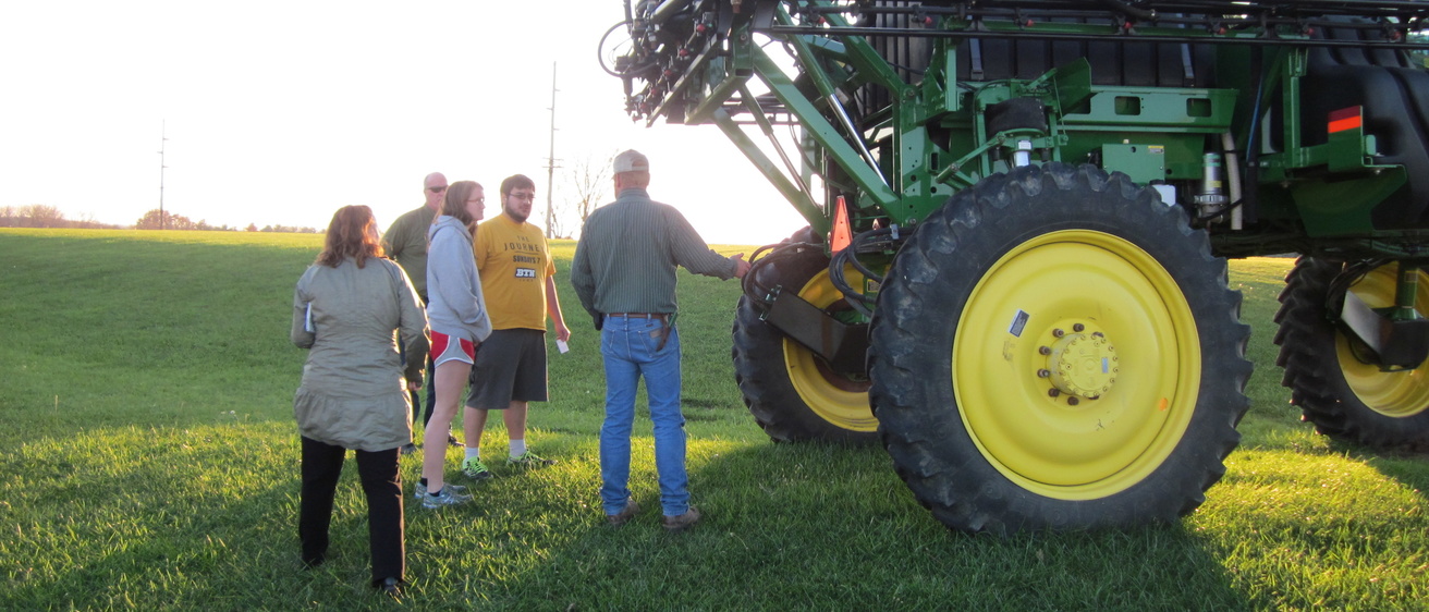Research tea members learning about a field sprayer