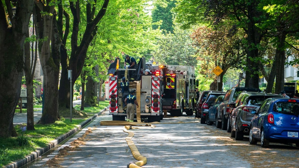A fire truck parked in the street with hose