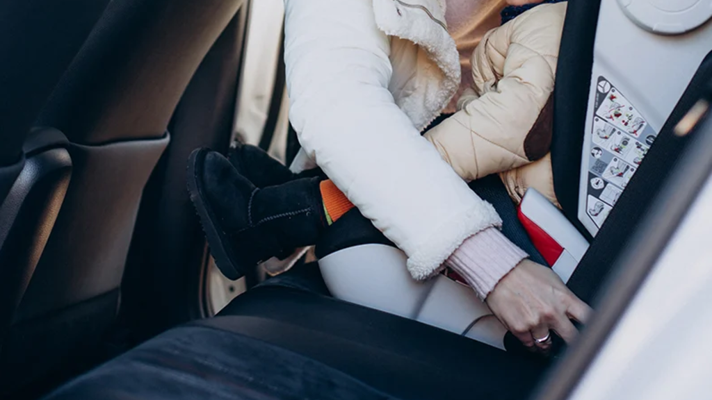 a child being buckled into a car seat